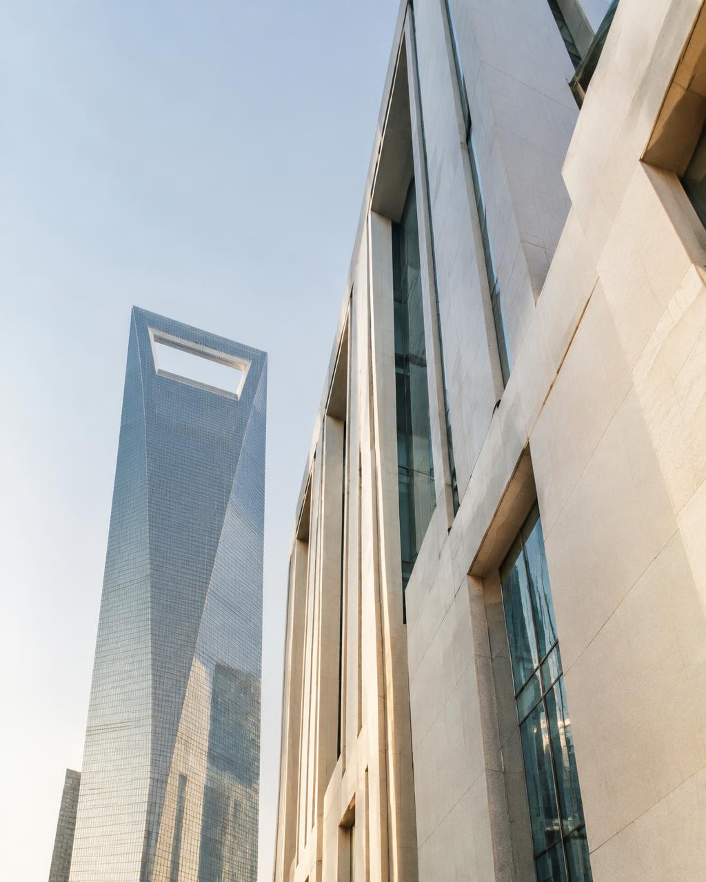 Pale stone facade beside the Shanghai World Financial Center in morning light